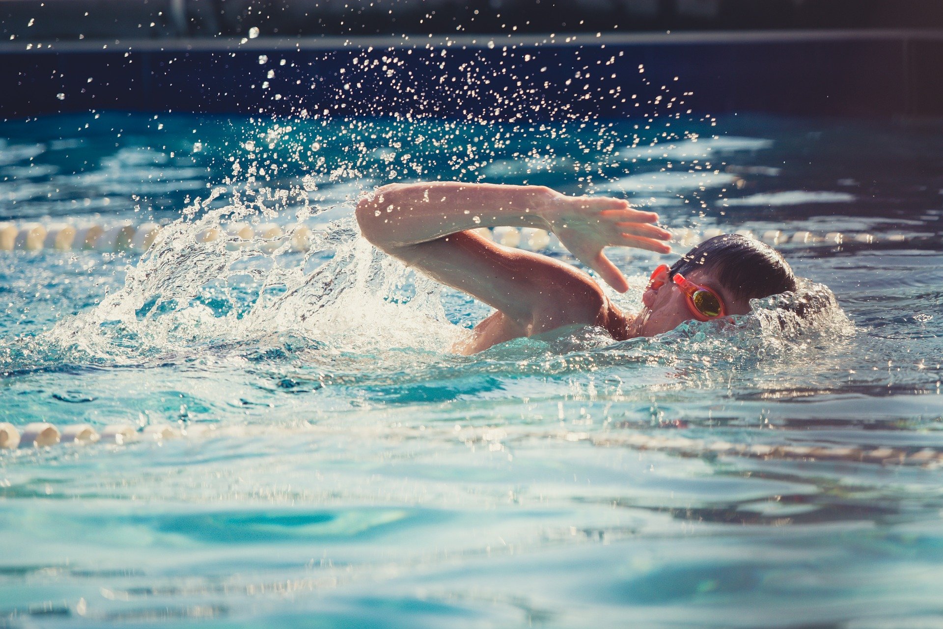 Mulher instrutora de natação mostra à menina como nadar com